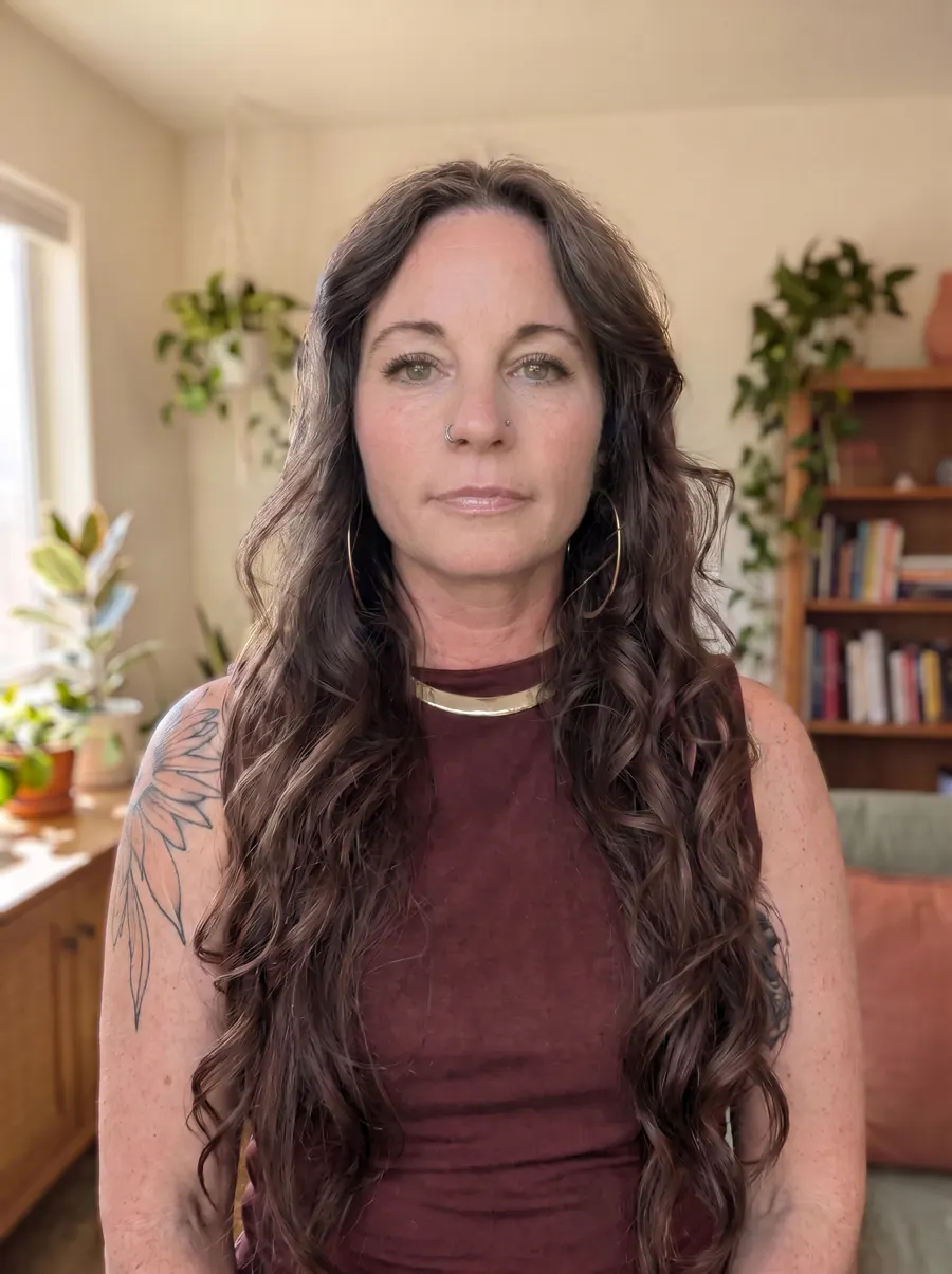 Jazmin Scott, life and holistic health coach, in a bright room with plants and a bookshelf